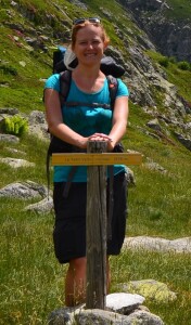 Jestem w masywie Ecrins (Alpy), zatrzymuję się do zdjęcia. Zmęczona, ale szczęśliwa, z plecakiem na plecach, oddycham górskim powietrzem. W tle rozpościera się malownicza panorama Alp.